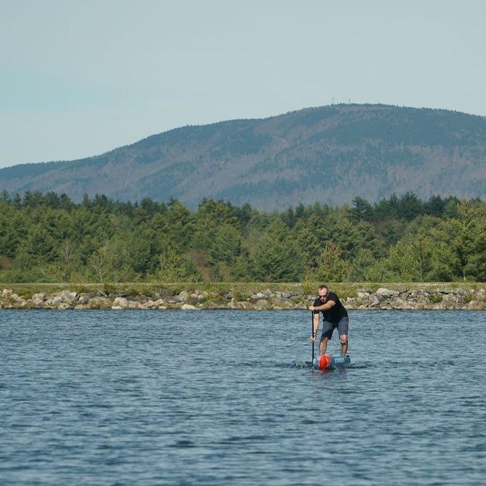 coach jonathan paddleboard training on the water in winhall, vt